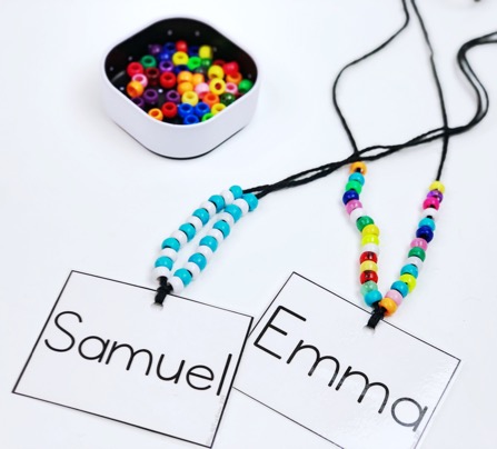 Back to school fine motor activity. Student name tags attached to yarn with beads strung onto the yarn.