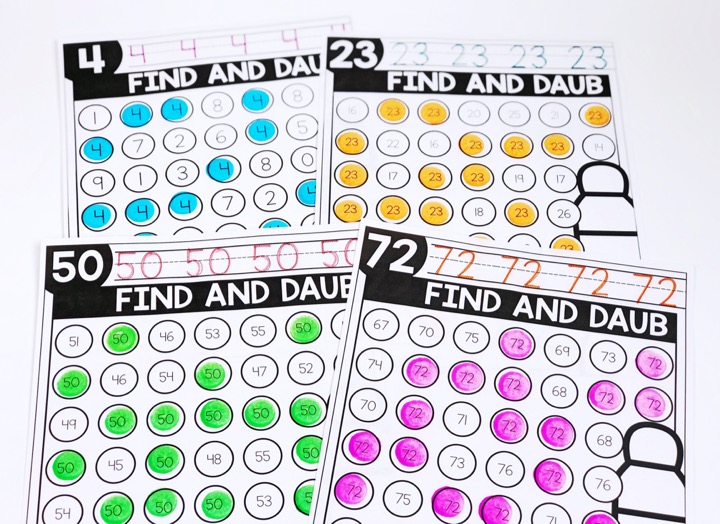 Number recognition activities: number daub pages. 4 pages laid out on a surface. Numbers 4, 23, 50, and 72 worksheets. Number traced at the top and matching number found and marked with a bingo dauber on the worksheets.