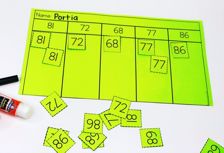Number recognition activities: number sorts. Green paper with 5 sorting spaces for numbers 81, 72, 68, 77, and 86. Number cards are cut apart and sorted into columns.